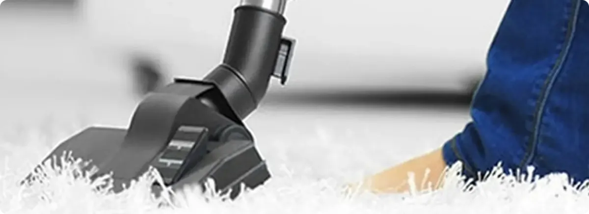 Close-up of a professional vacuuming a white carpet in Marne.